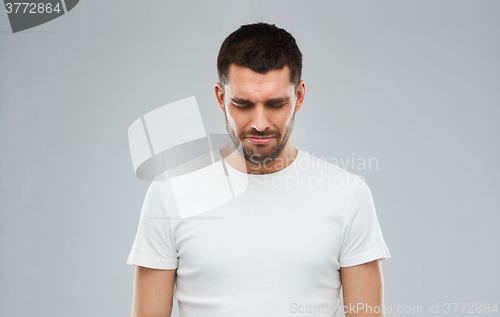 Image of unhappy young man over gray background