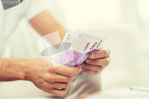 Image of close up of man hands counting money at home