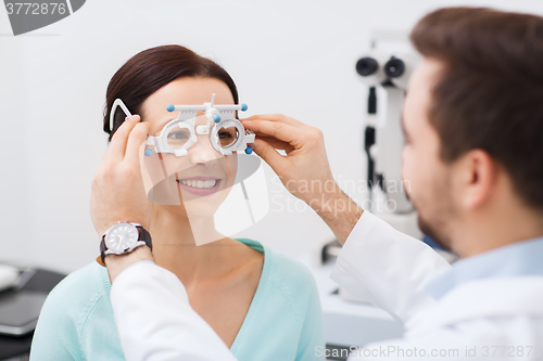 Image of optician with trial frame and patient at clinic