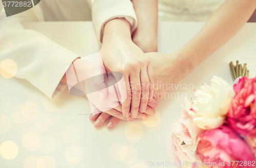 Image of close up of happy married lesbian couple hands