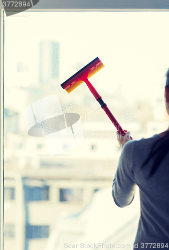 Image of close up of woman cleaning window with sponge