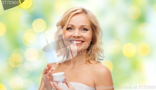 Image of happy middle aged woman with cream jar