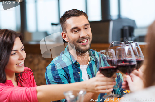 Image of friends clinking glasses of wine at restaurant