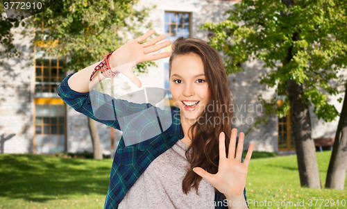 Image of happy teenage student girl showing hands 
