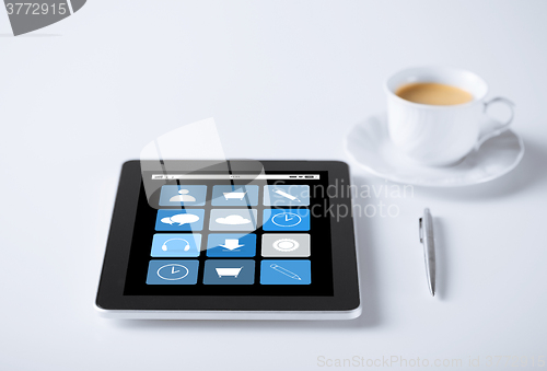 Image of tablet pc with application icons and cup of coffee