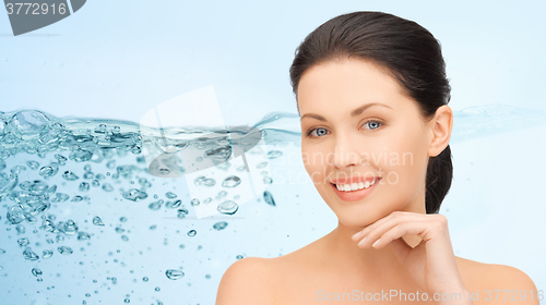 Image of smiling young woman touching her face