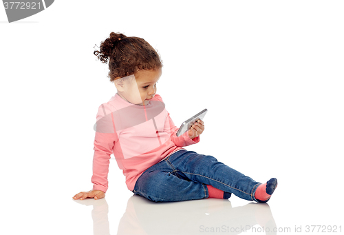 Image of smiling little baby girl playing with smartphone