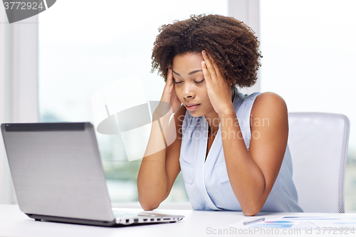 Image of african woman with laptop at office