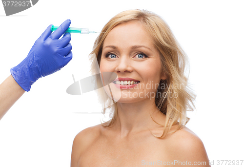 Image of happy woman face and beautician hand with syringe