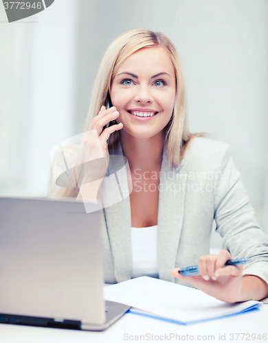 Image of businesswoman with laptop and cell phone