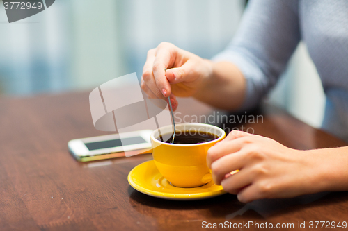 Image of close up of woman with smartphone and coffee