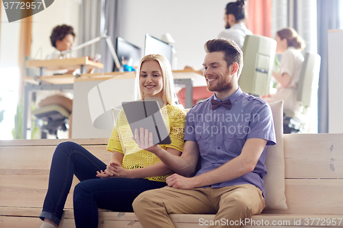 Image of happy creative team with tablet pc in office