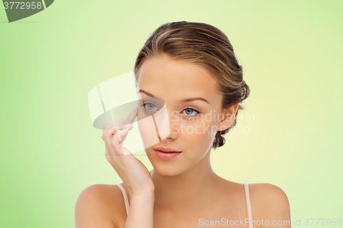 Image of young woman applying cream to her face