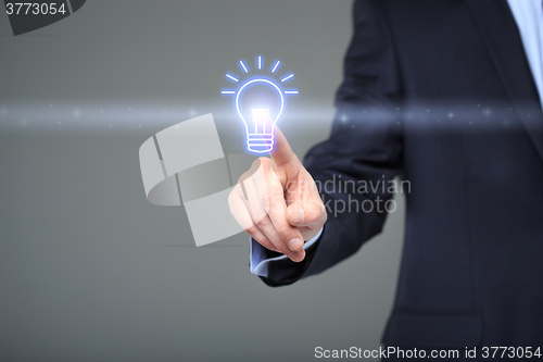 Image of technology and internet concept - businessman pressing button with bulb on virtual screens