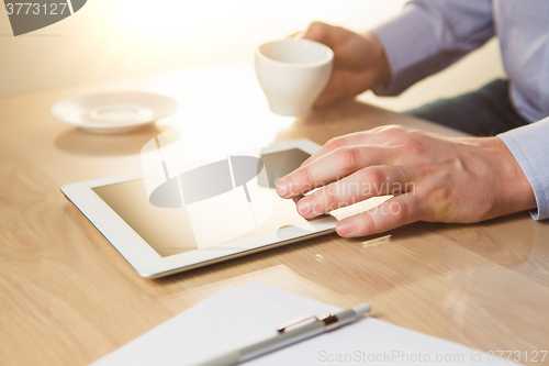 Image of The male hands with a laptop and the cup