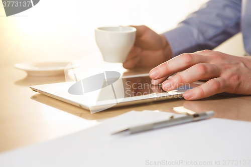 Image of The male hands with a laptop and the cup