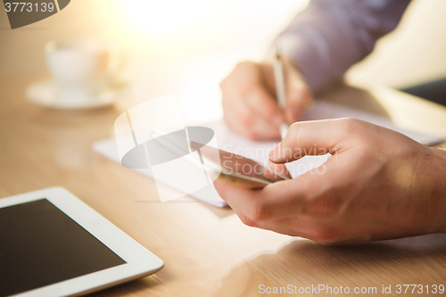 Image of The male hand holding a phone 