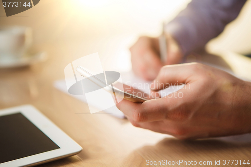 Image of The male hand holding a phone 