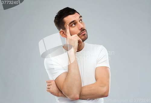 Image of man thinking over gray background