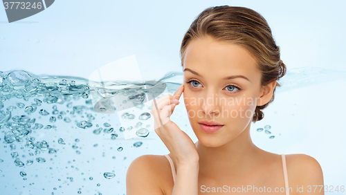 Image of young woman applying cream to her face