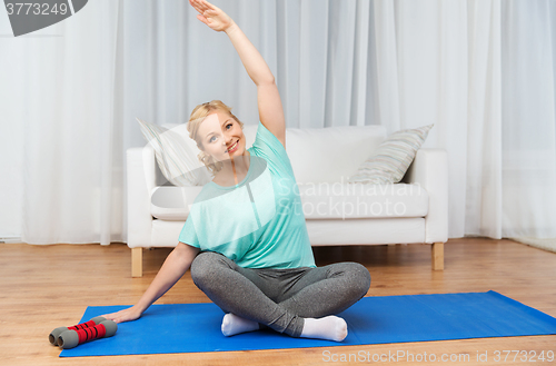 Image of woman making yoga meditation in lotus pose on mat