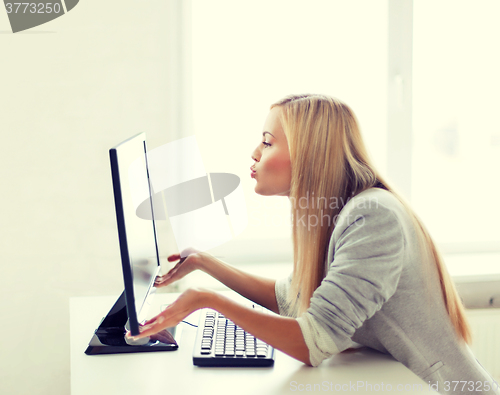 Image of woman sending kisses with computer monitor