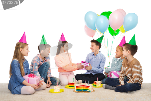 Image of happy children giving presents at birthday party