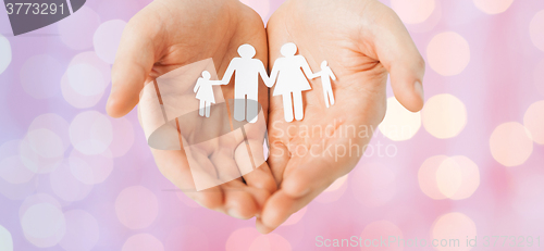 Image of man hands holding paper cutout of family