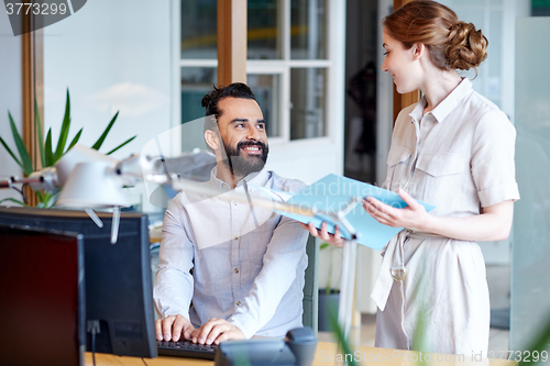 Image of business team with computer and files in office