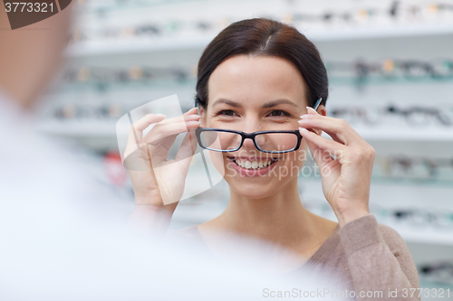 Image of woman showing glasses to optician at optics store