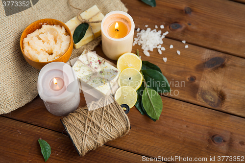 Image of close up of natural soap and candles on wood