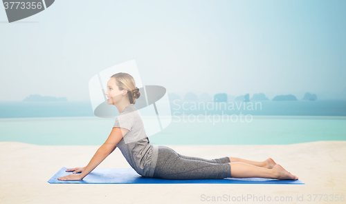 Image of woman making yoga in dog pose on mat