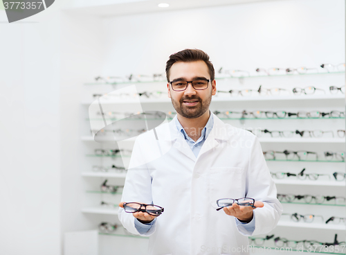 Image of man optician with glasses in coat at optics store