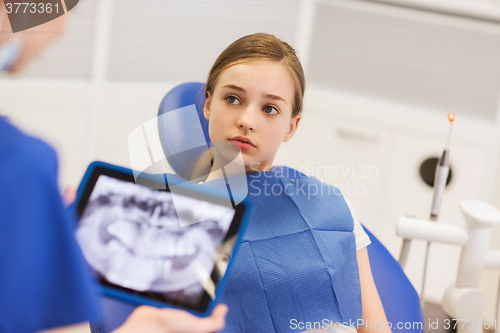 Image of dentist with x-ray on tablet pc and girl patient