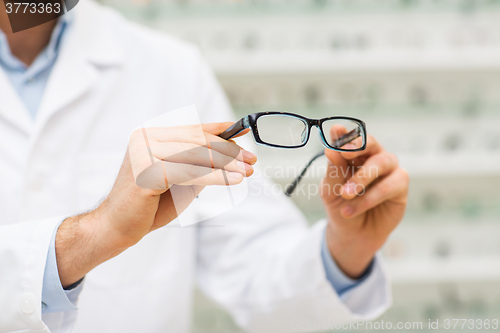 Image of close up of optician with glasses at optics store