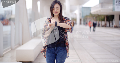 Image of Young woman checking her wristwatch