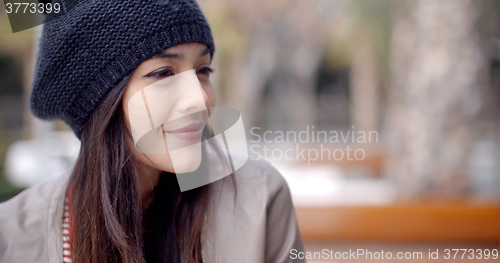 Image of Cute smiling young woman in knitted hat