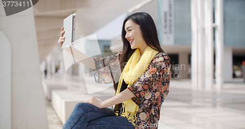 Image of Woman taking a self portrait with tablet