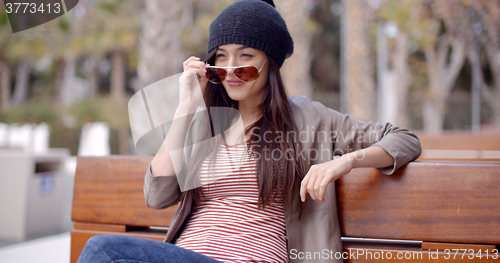Image of Trendy casual woman relaxing in a park