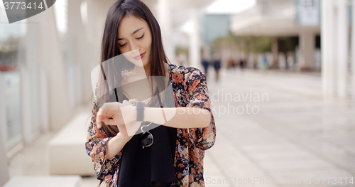 Image of Young woman checking her wristwatch