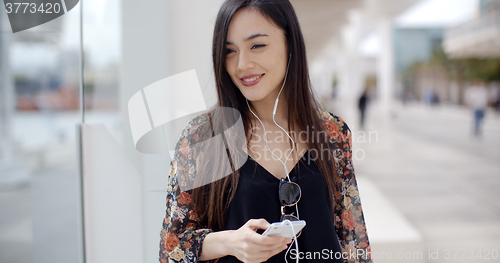 Image of Smiling young woman walking through town