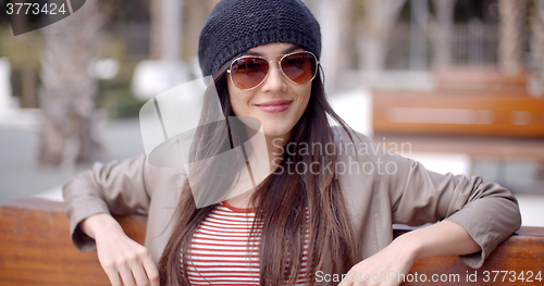 Image of Happy relaxed trendy woman sitting daydreaming