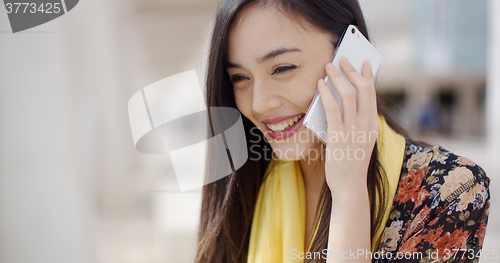 Image of Young woman listening to a call on her mobile