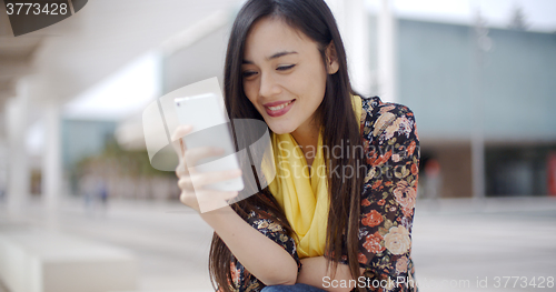 Image of Chic young woman reading a mobile message