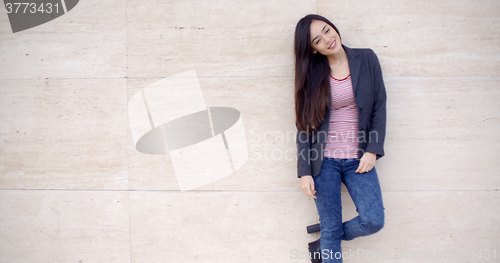 Image of Trendy young woman posing against a wall