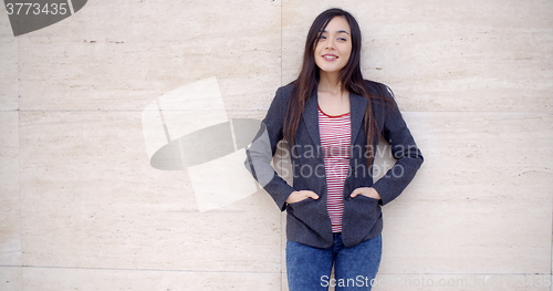 Image of Trendy young woman posing against a wall