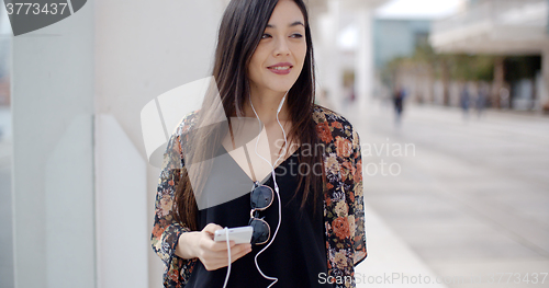 Image of Smiling young woman walking through town