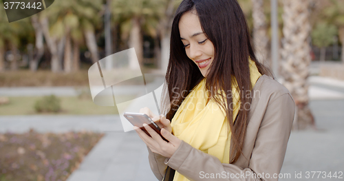 Image of Stylish woman checking a message on her mobile