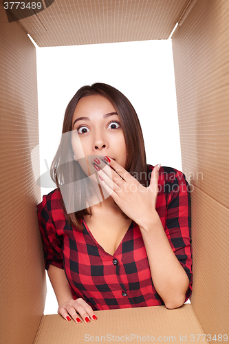 Image of Girl opening a carton box and looking inside