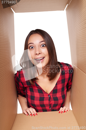 Image of Girl opening a carton box and looking inside